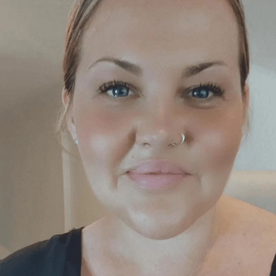 A woman with a silver nose ring in a black top.